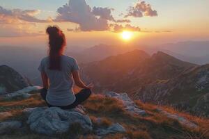 Embracing tranquility at sunset on the mountain peak in peaceful meditation. photo