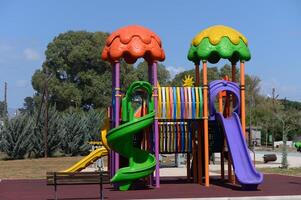 Colorful playground structures invite joyful play under a bright blue sky in a sunny park setting photo