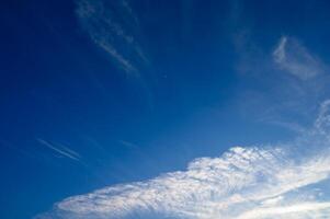 Expansive azure sky adorned with wispy clouds at midday revealing a atmosphere photo
