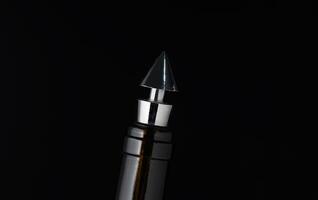 Elegant metallic pen tip shines against a dark background, showcasing exquisite craftsmanship and design in a close-up perspective photo
