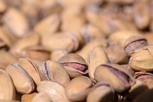 Pistachio nuts in natural light highlight their texture and unique shells amid a warm, inviting setting at a local market photo