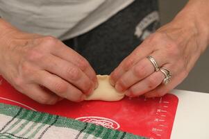 Creating delicate dumplings with skillful hands in a cozy kitchen during a rainy afternoon photo