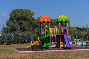 Colorful playground structure invites joyful play under a clear blue sky in a serene park setting photo
