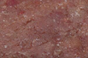 Richly textured ground meat displayed on a cutting board in a cozy kitchen setting during afternoon preparation photo