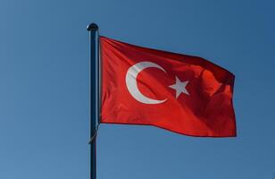 Waving flag of Turkey against a clear blue sky, symbolizing national pride and unity in the heart of the country on a sunny day photo
