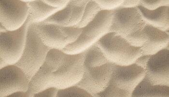 close up of fine sand in warm beige shade with thin edges and small mounds creating interesting patterns. Shadows add depth and contrast to the texture, creating a relaxing atmosphere. photo