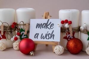 Greeting card with text MAKE A WISH New year and Christmas preparation. Four-week advent candles on table. Handmade eco-friendly decor. Sustainable Christmas decoration. Postcard photo