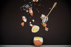 simple breakfast.Boiled egg with spices and shell on black background photo