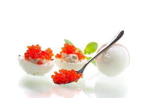 Quickly prepared breakfast.boiled eggs with red caviar on a white background photo