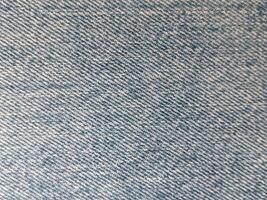 An up-close view of denim fabric showcases its texture and weave, emphasizing its classic and timeless appearance. photo