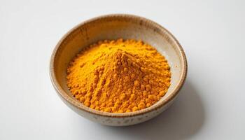 A bowl filled with bright yellow turmeric powder, showcasing its rich color and texture, ideal for culinary uses and health benefits. photo