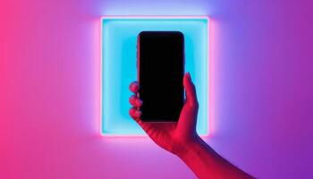 A hand holding a smartphone is illuminated by colorful lights, showcasing modern technology and digital connectivity in a vibrant setting. photo