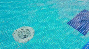 Cleaning of the drain valve filter at the bottom of the swimming pool, movement of clear water, top view. photo