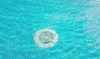 Cleaning of the drain valve filter at the bottom of the swimming pool, movement of clear water, top view photo