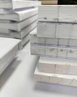 Close-up, a stack of glued book blocks prepared for binding in a printing house, vertical photo