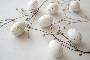Elegant white Easter eggs adorned with delicate gold detailing nestled amongst blossoming twigs, creating a serene springtime scene. photo