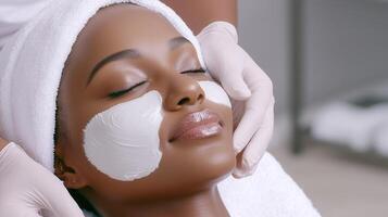 applying a rejuvenating white clay face mask to a relaxed woman during a spa treatment photo