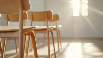 Sunlight is streaming into an empty classroom, illuminating peaceful of wooden chairs and creating a rows atmosphere photo