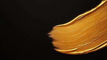 Golden paint elegance stroke splashing across dark surface, representing artistic brush and luxurious graphic design element photo