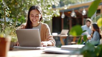 Two young female college students smiling and working together on a laptop, enjoying a sunny day university the in campus garden, studying and preparing for exams friends outdoors on a sunny terrace photo