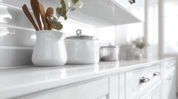 White kitchen cabinet displaying stacked bowls, amber vase with magnolia blooms, decorative elements bathed natural in soft lighting photo