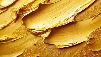 Gold paint across backdrop textured surface, creating elegant artistic smearing with metallic shimmer photo