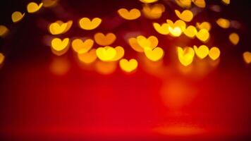 Golden heart-shaped bokeh lights create a warm, romantic atmosphere against a vibrant red backdrop, perfect for valentine's day themes and love-inspired designs photo