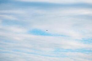 Small airplane soaring high in a partly cloudy sky, leaving a white contrail behind on a stunning summer day filled with sunshine and adventure in the atmosphere photo