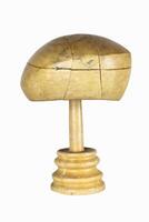 Antique millinery form for shaping berets and hats on a stand. Vintage wooden block. Craftsmanship, old professions, artisan work concept. Isolated on white background. Copy space photo