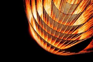 Abstract spiral with glowing red and orange tones and wire texture against a black background, symbolizing energy, motion, industrial and futuristic design concepts. Copy space 05 photo