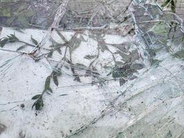 Broken and damaged glass is lying on the green spring grass for recycling. photo