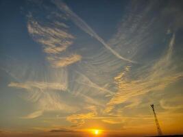 Feathery pink clouds spread out against the sunset sky. photo