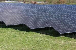 Photovoltaic panels providing clean energy in a field near a highway photo