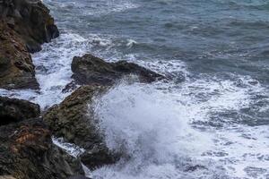 Ocean waves crashing against rocks in Iceland photo