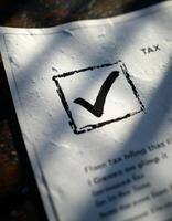 A closeup of a tax document with a checkmark showing completion under sunlight photo