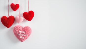 Hanging plush heart decorations in shades of red and pink for Valentines Day on a white background photo
