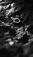 Monochrome image of a hand icon with wifi symbol on a textured surface photo