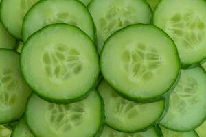 Sliced fresh cucumbers as a background. photo