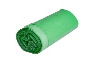 Garbage bags in a roll, green color, isolate. Recycled material, garbage bag on a white background. photo