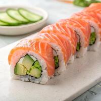 Fresh Salmon Sushi Rolls with Avocado and Cucumber Slices on Stone Tray photo