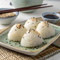Onigiri Rice Balls Sprinkled With Sesame Seeds On Plate Over Tabletop Still Life photo