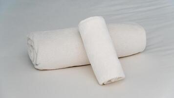White towel rolled up on the bed. Beautiful layout for a resort welcome. photo
