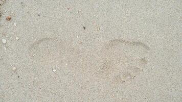 Above view of single footprints of people on the sandy beach. for background and textured of dry beach. photo