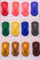 A row of colorful car paint samples are displayed on a white background photo