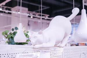 A white cat statue is on display in a store photo