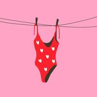 A red swimsuit with a white heart pattern hanging on a clothesline under the sun. vector