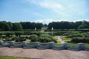 A beautiful garden with a fountain and a stone wall photo