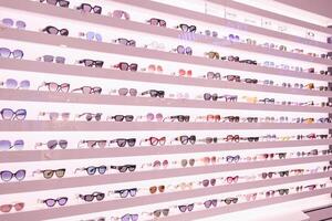 A row of eyeglasses on display in a store photo