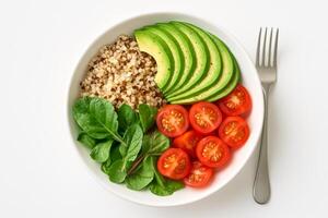 Vegan lunch bowl with avocado, quinoa, spinach and cherry tomatoes on white background, top view of healthy plant-based meal photo