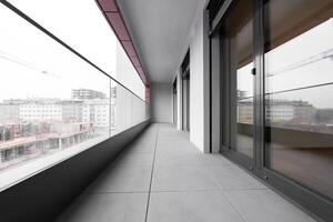 Modern city balcony with glass railing and urban construction view photo